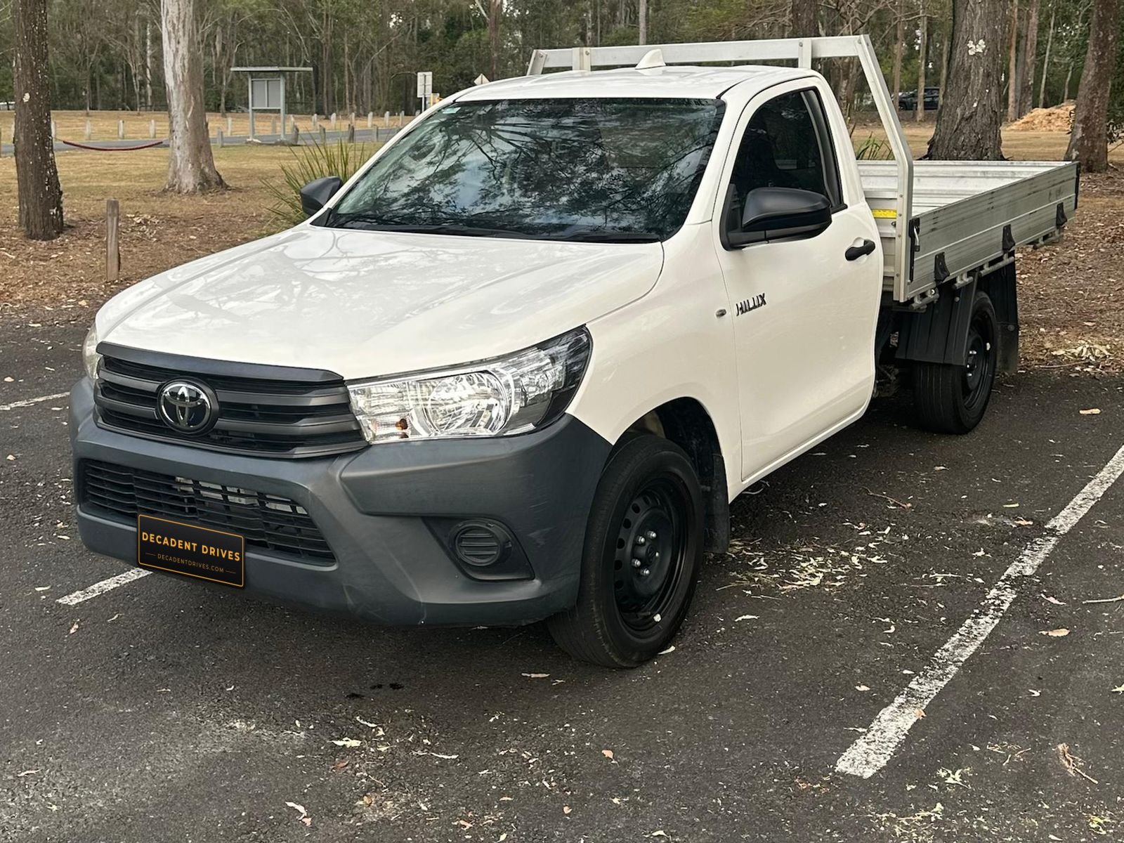 White 2022 Toyota Hilux single-cab tray ute, front three-quarter view showing the alloy tray – self-drive hire in Brisbane