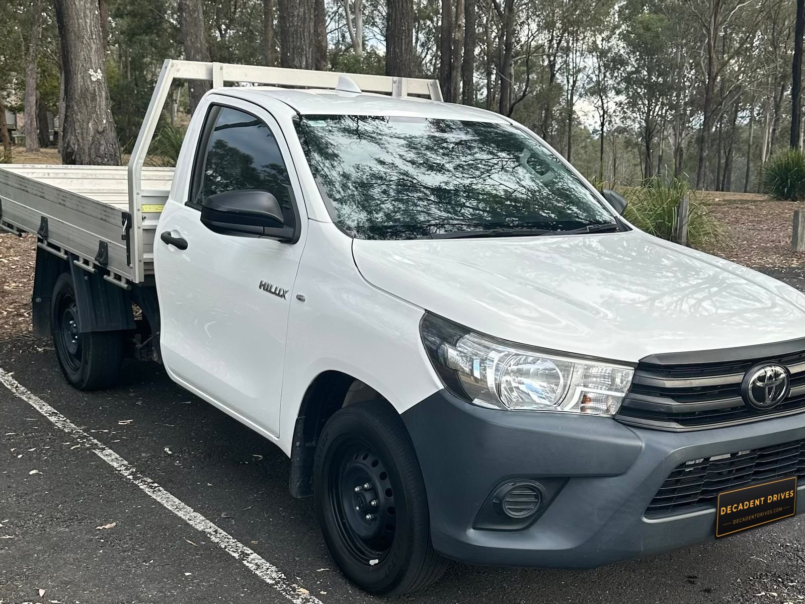 White 2022 Toyota Hilux single-cab tray ute, side view showing the alloy tray